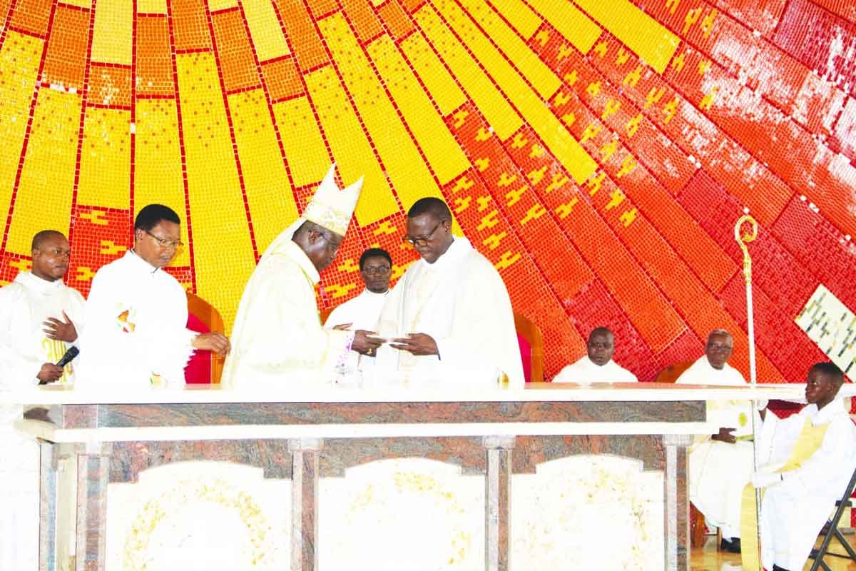 Le Père-curé Paul Akplogan remettant à Mgr Aristide Gonsallo, évêque de Porto-Novo, les reliques de Saint Jean-Paul II, pour la consécration de l'église de Vakon, le 28 mars 2026